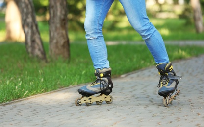 Photo of Man roller skating in summer park, closeup of legs