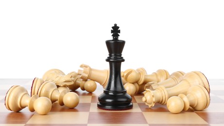 Photo of King among fallen chess pieces on wooden board against white background
