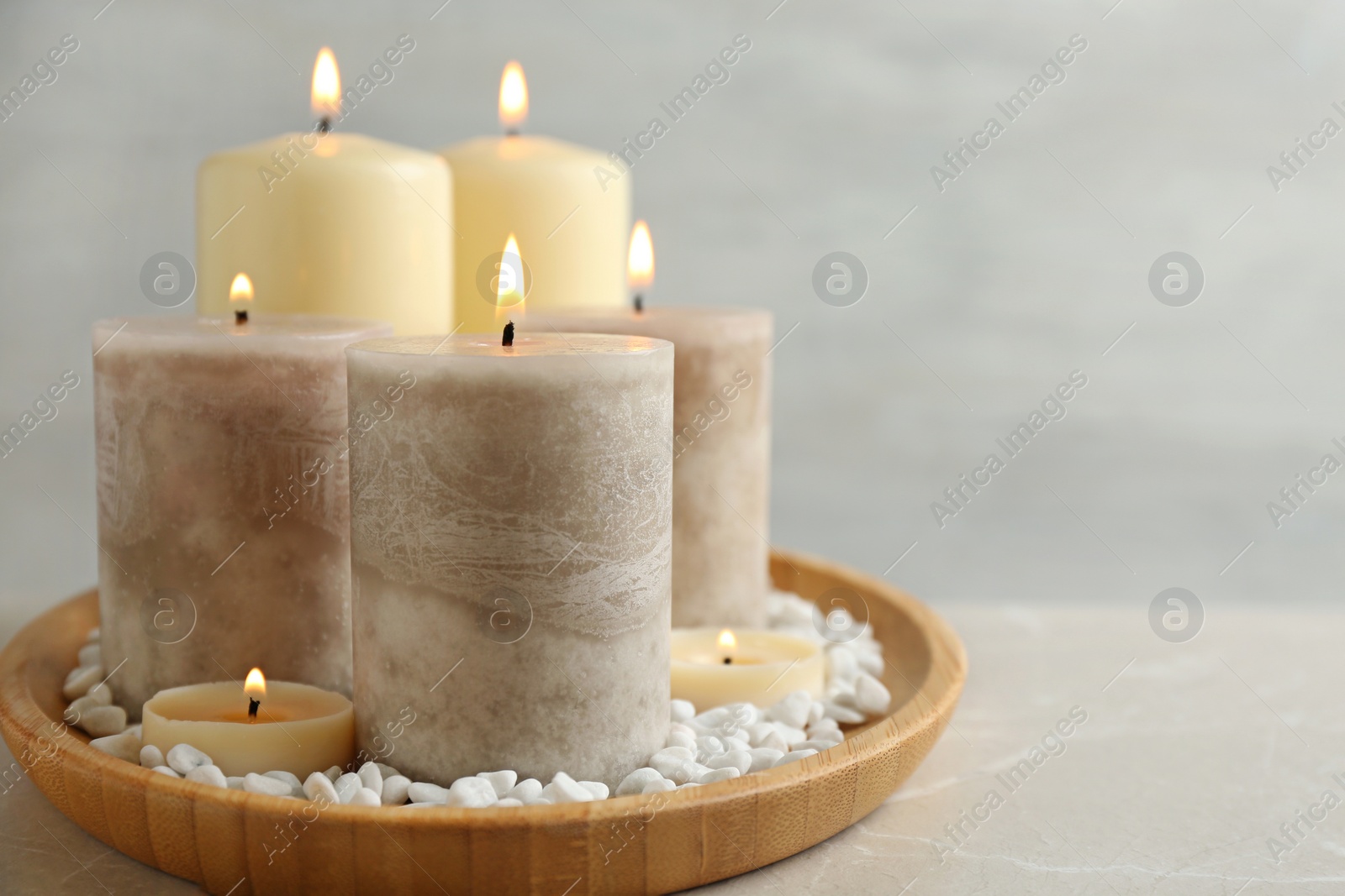 Photo of Plate with different candles and rocks on table, space for text