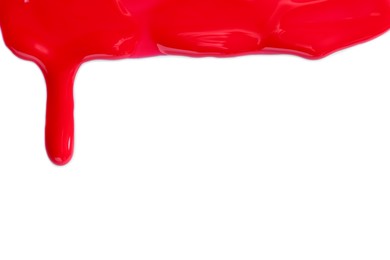 Photo of Red nail polish flowing on white background