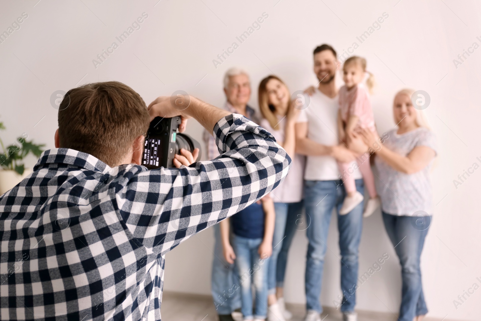 Photo of Professional photographer taking photo of family in studio