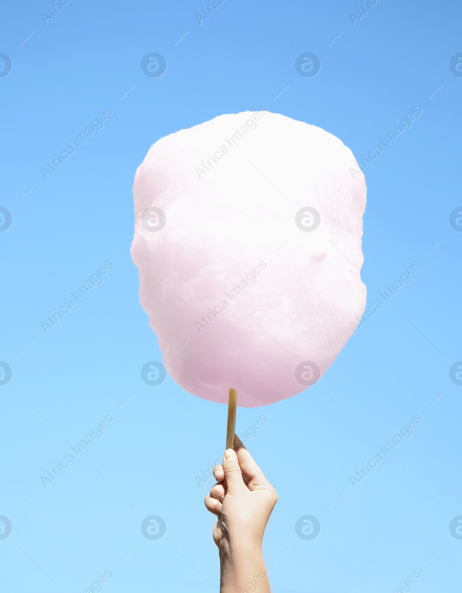 Photo of Woman holding white cotton candy against blue sky