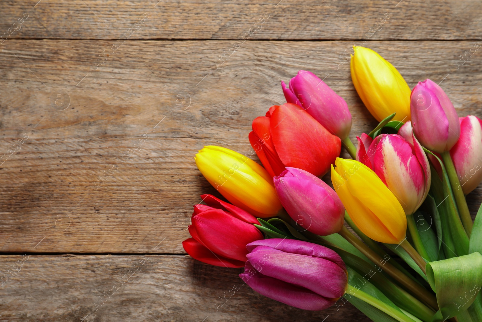 Photo of Beautiful tulips and space for text on wooden background, top view. Spring flowers