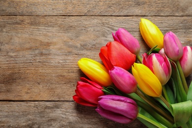 Beautiful tulips and space for text on wooden background, top view. Spring flowers