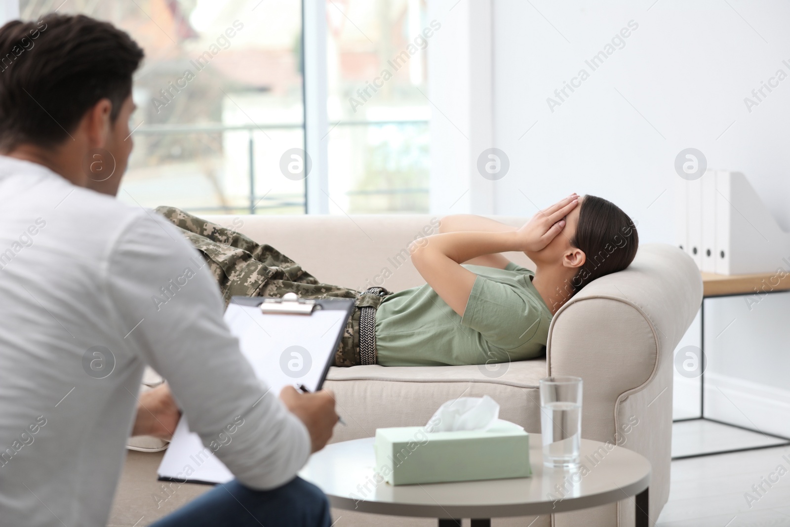 Photo of Psychotherapist working with female military officer in office