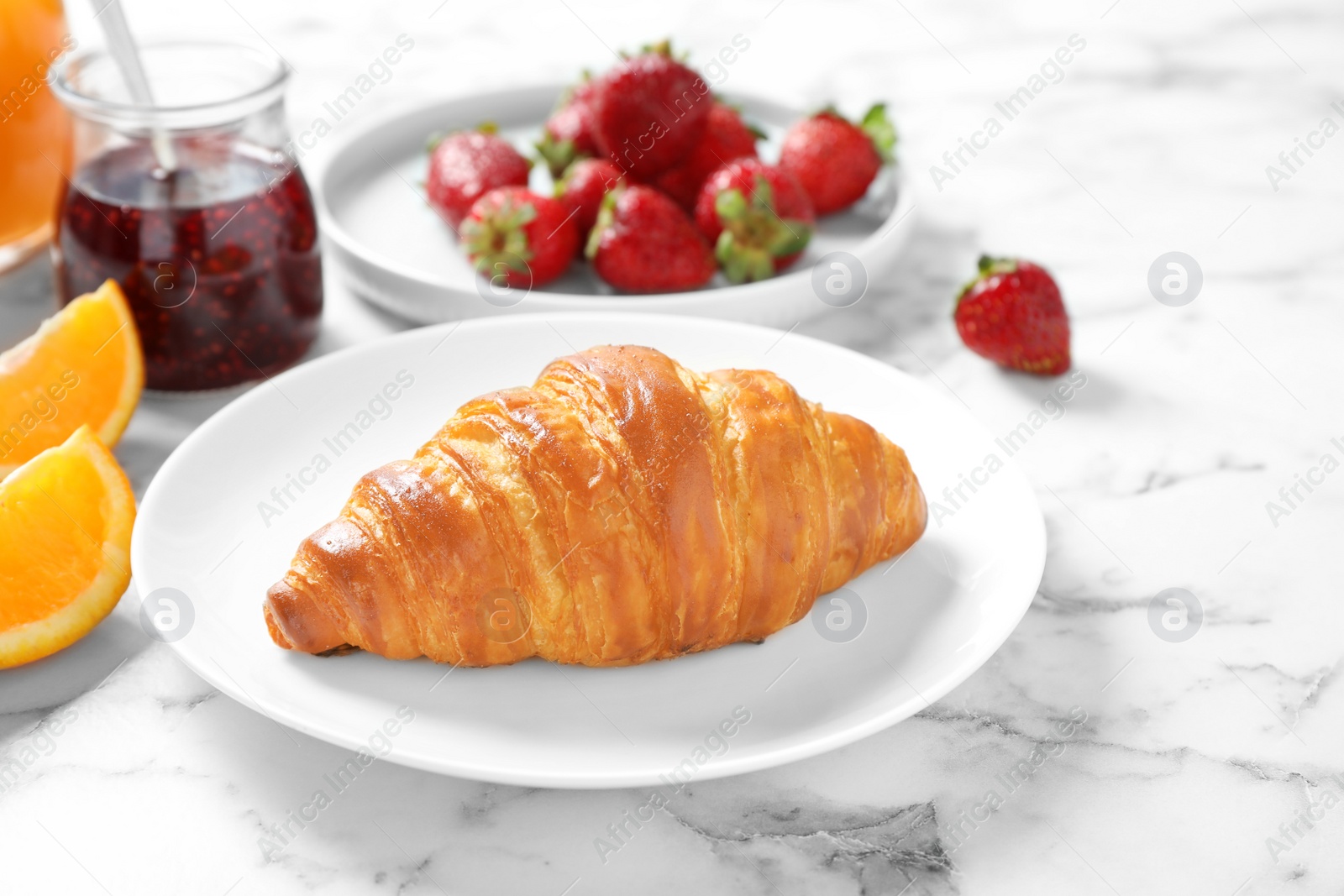 Photo of Tasty breakfast with croissant served on white marble table