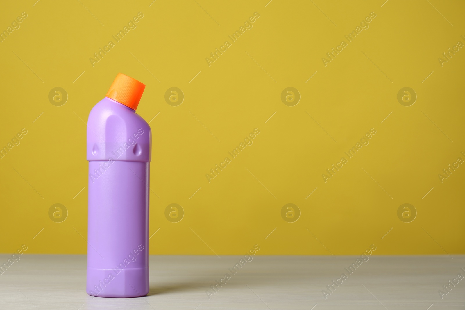 Photo of Bottle of cleaning product on light table. Space for text