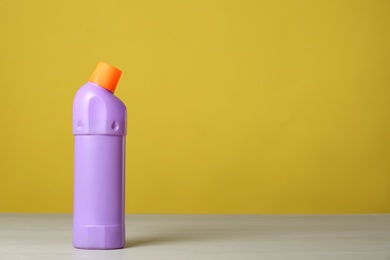 Photo of Bottle of cleaning product on light table. Space for text