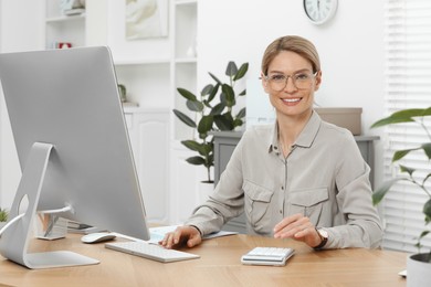 Professional accountant working at wooden desk in office