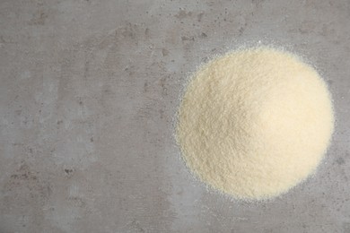 Photo of Pile of gelatin powder on grey table, top view. Space for text