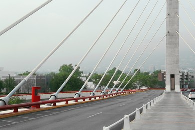 Beautiful view of modern bridge with asphalt road near mountain