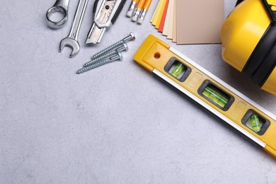 Photo of Flat lay composition with building level and other construction tools on grey table, space for text