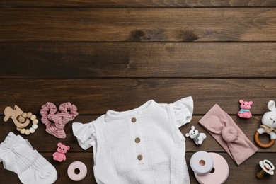 Flat lay composition with baby clothes and accessories on wooden table. Space for text