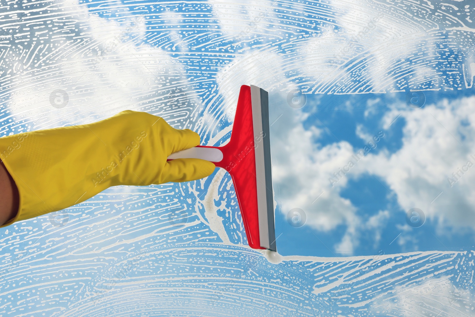 Photo of Woman cleaning glass with squeegee indoors, closeup