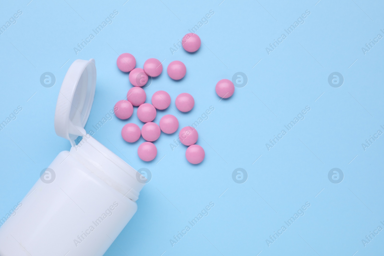 Photo of Bottle and antidepressant pills on light blue background, flat lay. Space for text