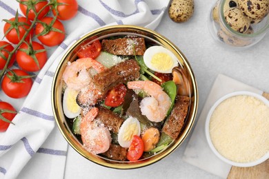 Photo of Delicious salad with croutons, tomatoes and shrimp served on white table, flat lay