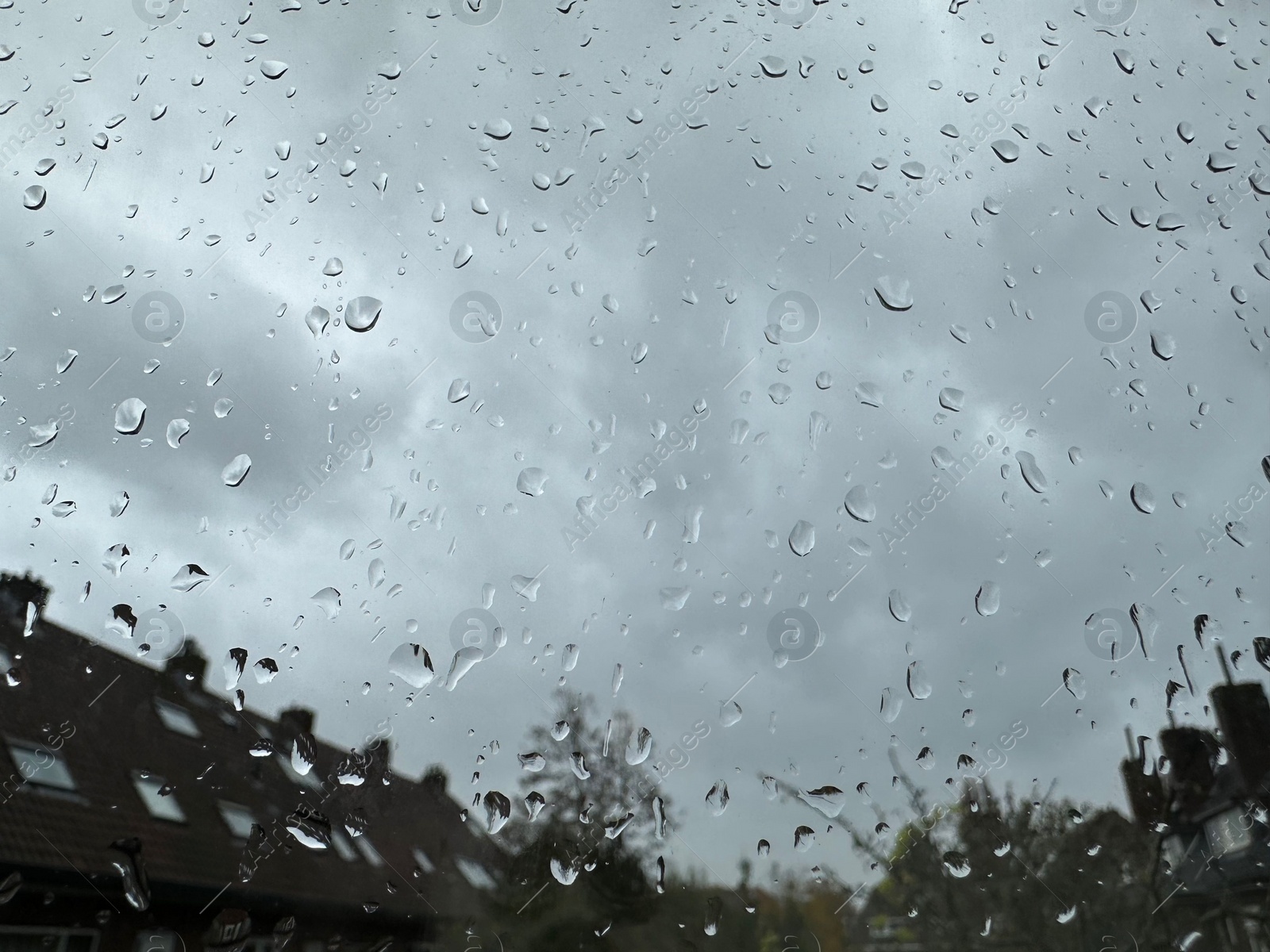 Photo of Window with water droplets on rainy day, closeup