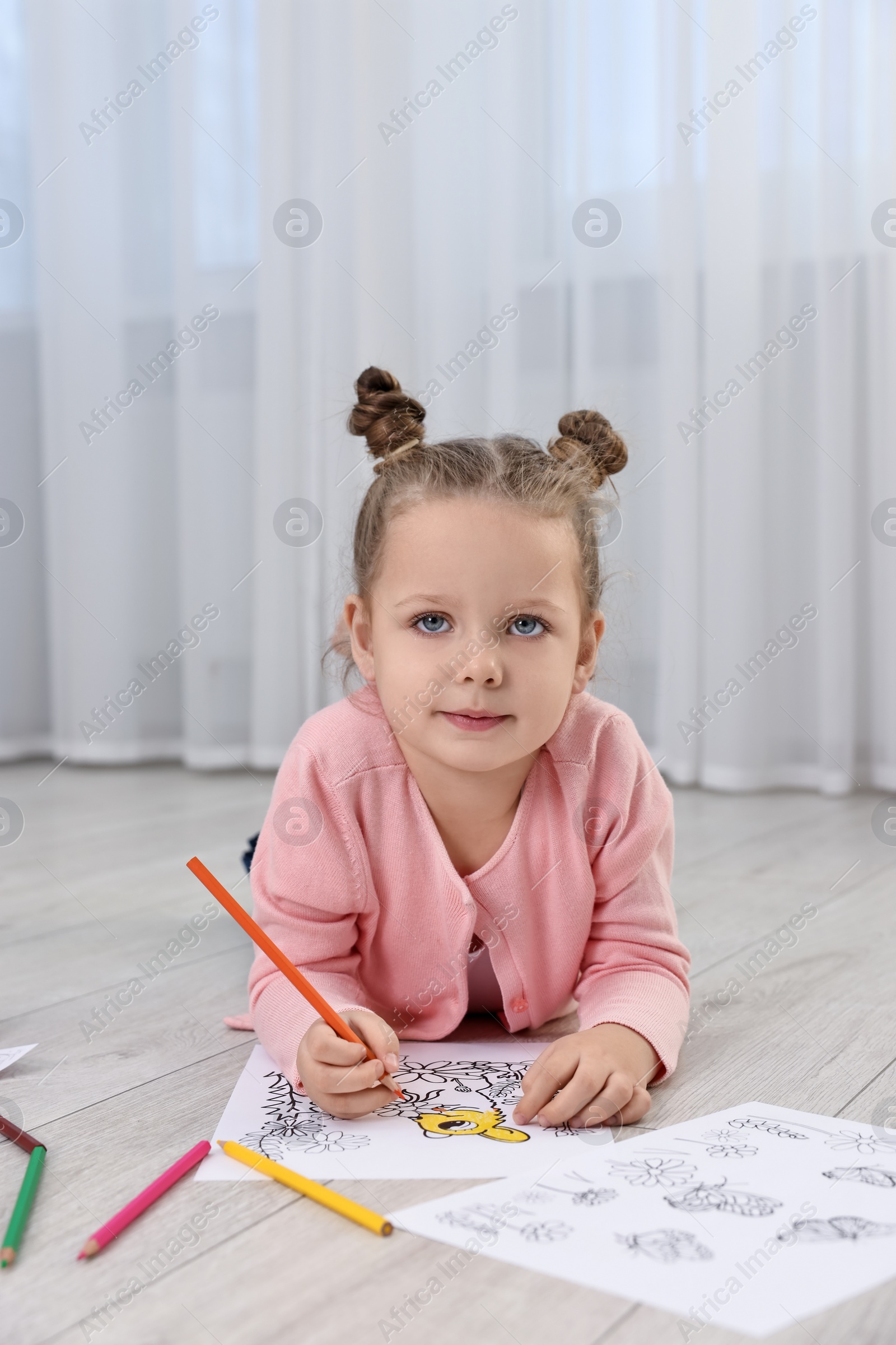 Photo of Cute little girl coloring on warm floor at home. Heating system