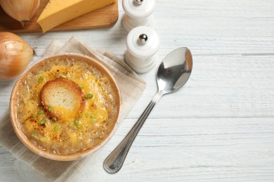 Photo of Tasty homemade french onion soup served on white wooden table, flat lay. Space for text