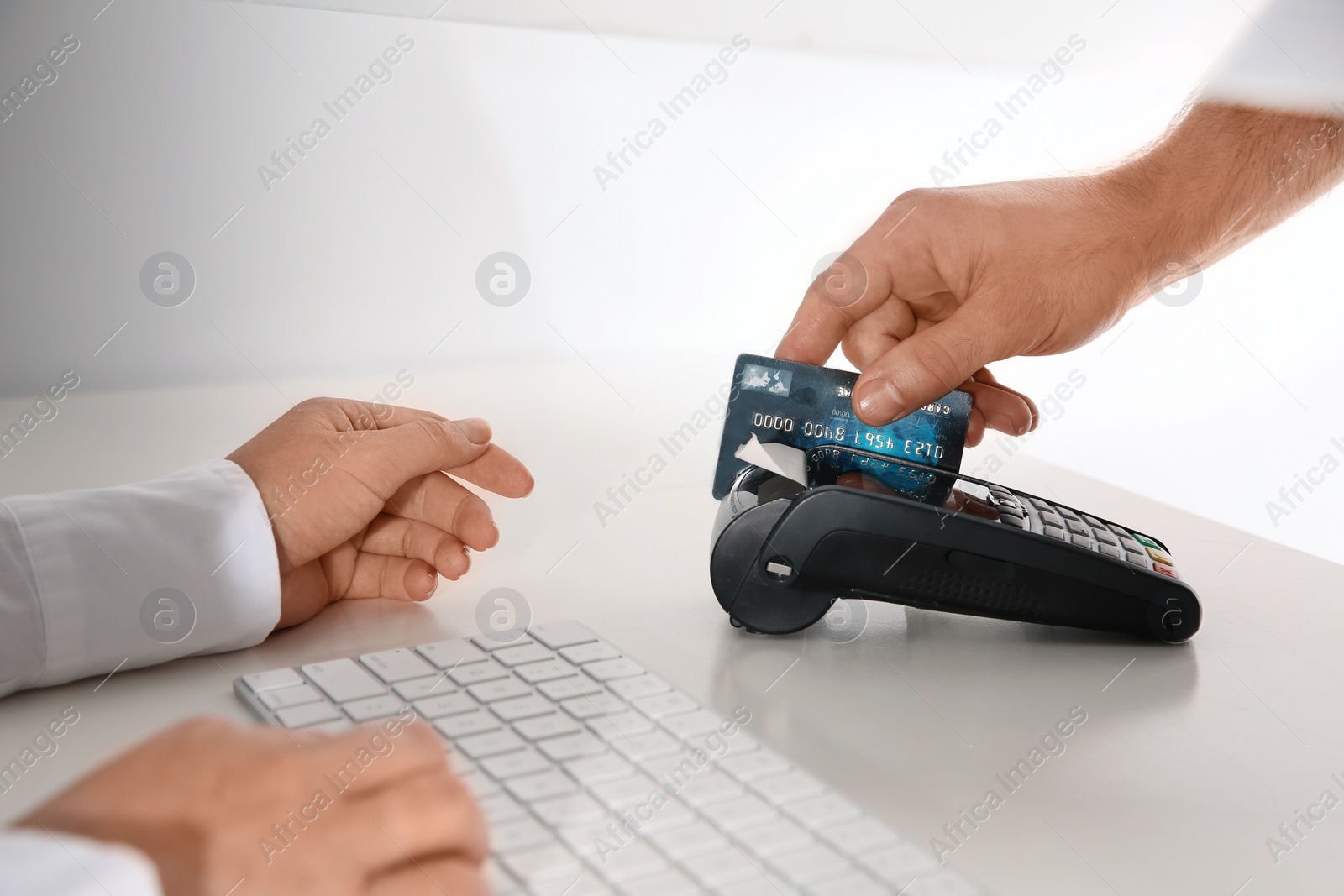 Photo of Man using bank terminal for credit card payment at cash department window, closeup