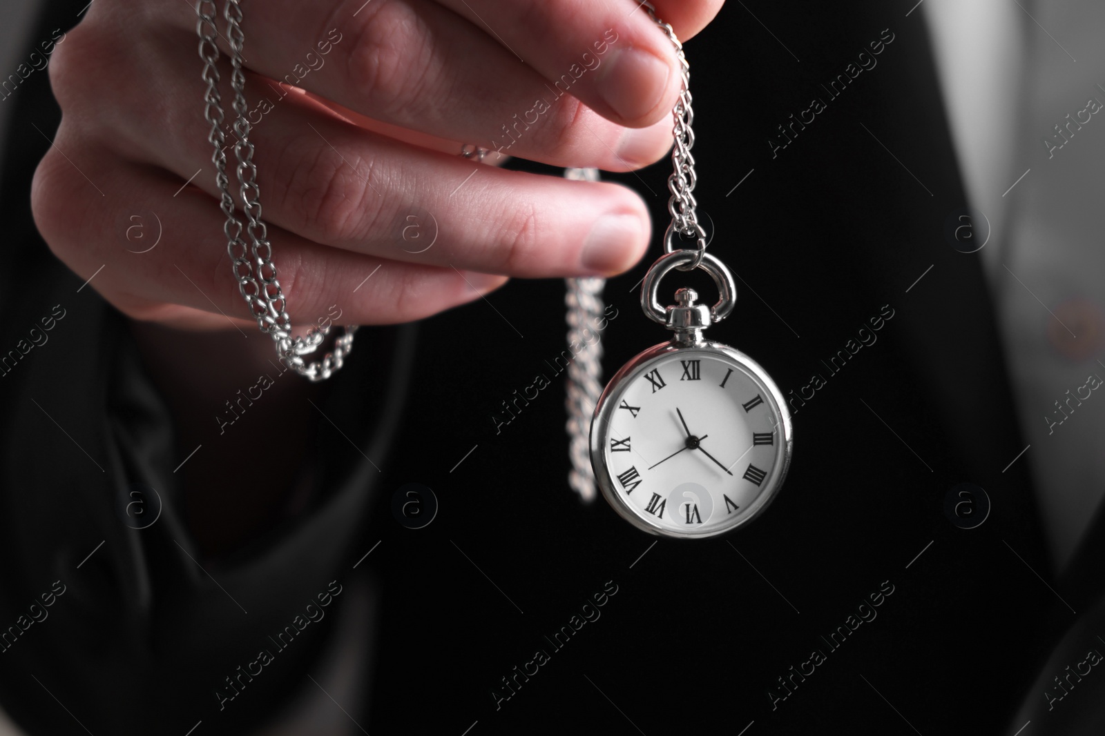 Photo of Man holding chain with elegant pocket watch, closeup