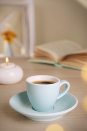 Photo of Cup of aromatic coffee on wooden table indoors. Bokeh effect