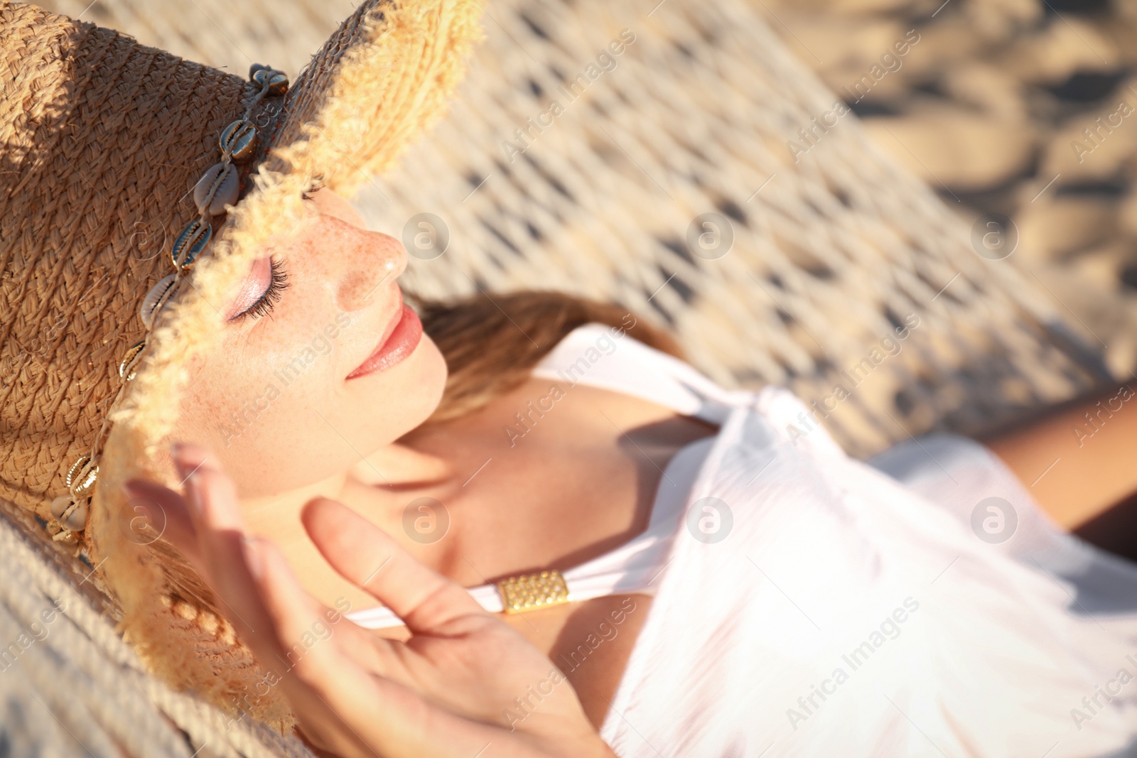 Photo of Young woman relaxing in hammock on beach