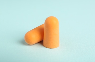 Photo of Pair of orange ear plugs on turquoise background