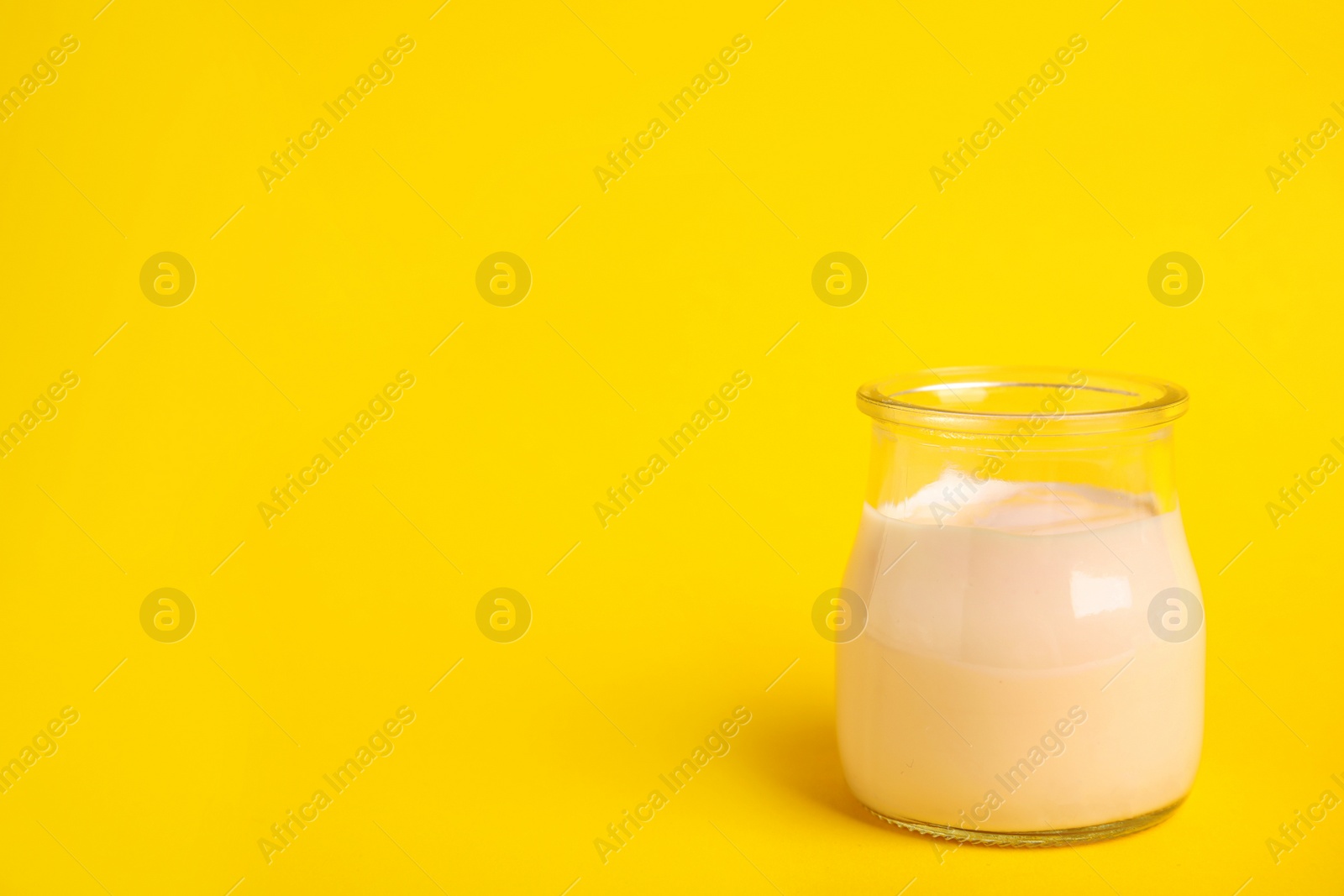 Photo of Tasty organic yogurt on yellow background. Space for text