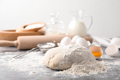 Photo of Wheat dough and products on grey table. Cooking pastries