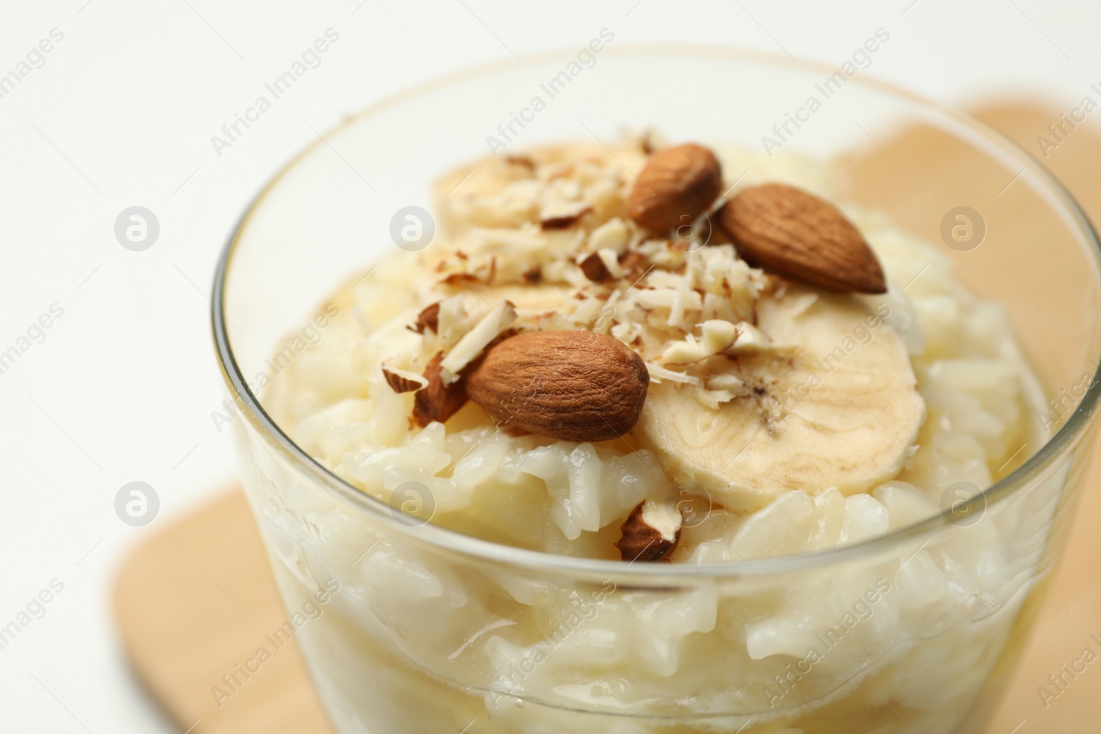 Photo of Delicious rice pudding with banana and almonds, closeup