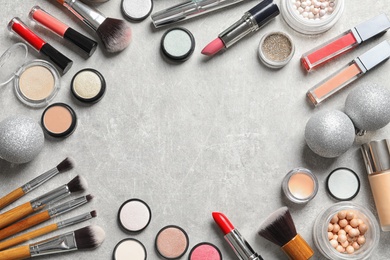 Photo of Flat lay composition with makeup products and Christmas decor on gray background. Space for text