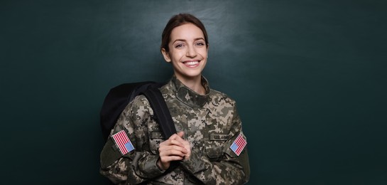 Image of Military education. Cadet with backpack near green chalkboard