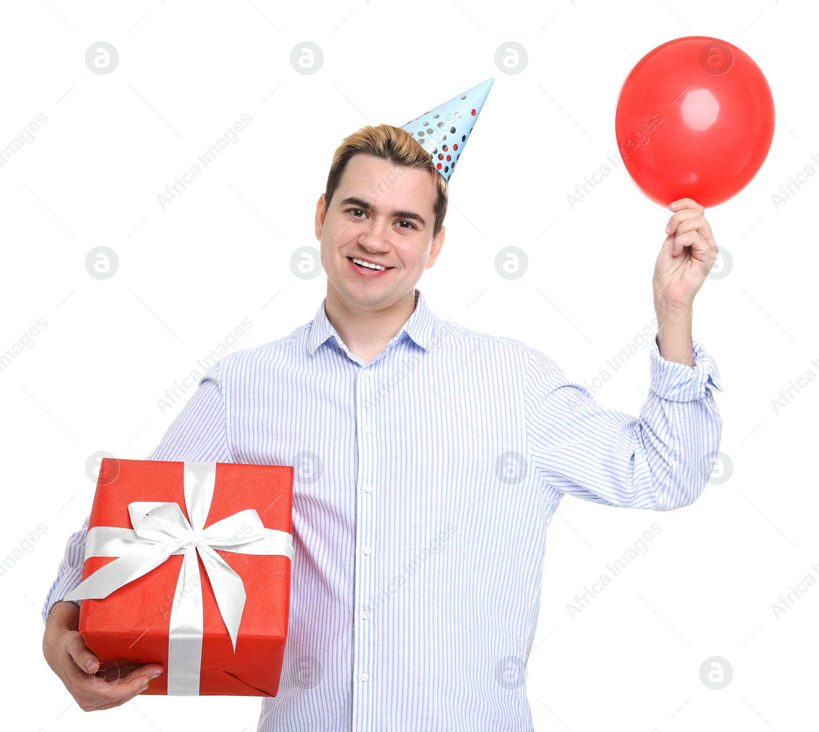 Photo of Young man with party hat, gift box and balloon on white background