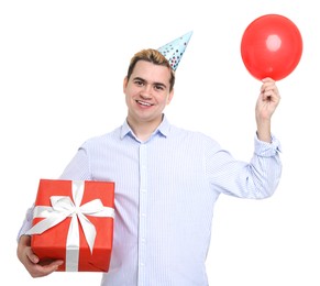 Young man with party hat, gift box and balloon on white background