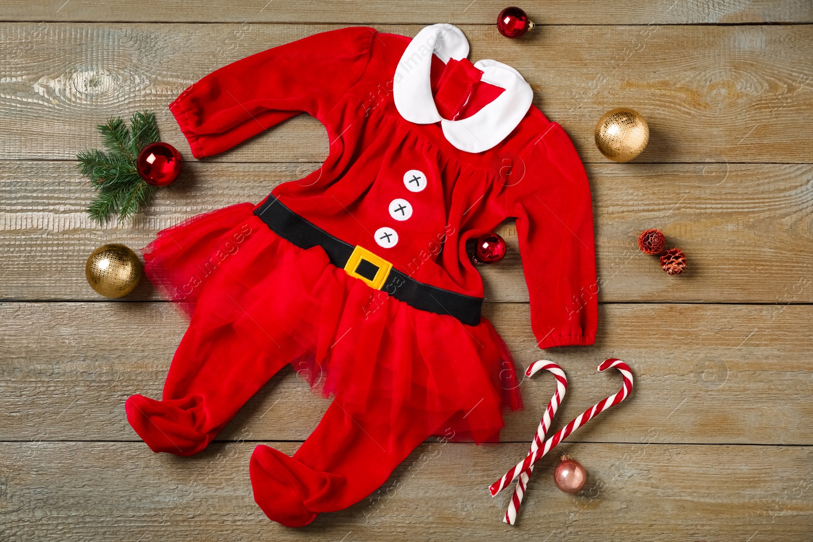 Photo of Flat lay composition with cute Christmas baby clothes on wooden background