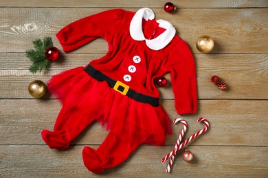 Flat lay composition with cute Christmas baby clothes on wooden background