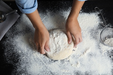 Photo of Woman making dough for pastry on table
