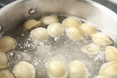 Closeup of metal stewpan with boiling water and dumplings. Home cooking