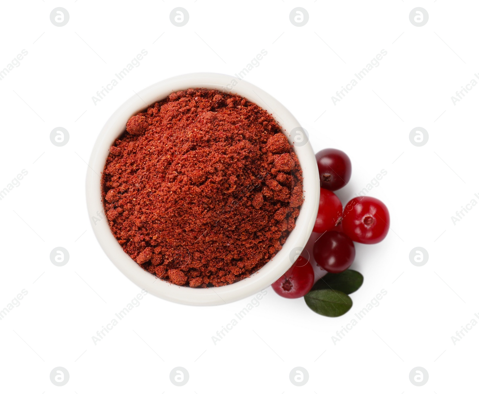 Photo of Dried cranberry powder in bowl, fresh berries and green leaves isolated on white, top view