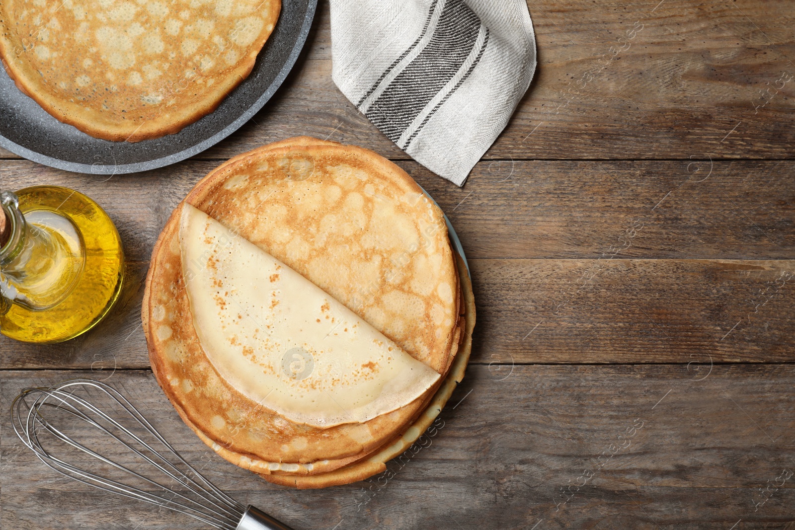 Photo of Flat lay composition with thin pancakes on wooden table