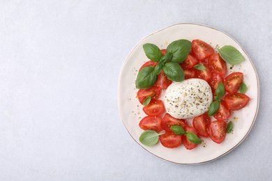 Photo of Tasty salad Caprese with mozarella, tomatoes and basil on light table, top view. Space for text