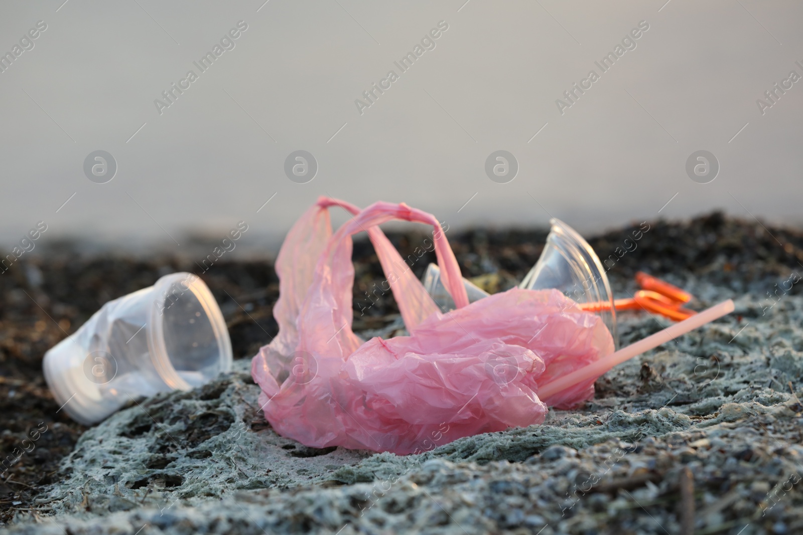 Photo of Plastic garbage at beach, closeup and space for text. Environmental pollution concept