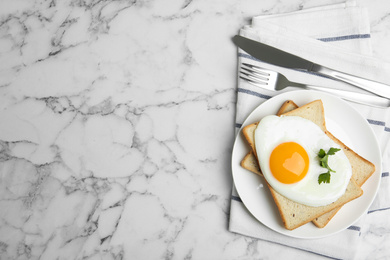 Photo of Tasty fried egg with bread on white marble table, flat lay. Space for text