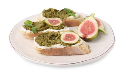 Photo of Plate of tasty bruschettas with cream cheese, pesto sauce, figs and fresh basil isolated on white