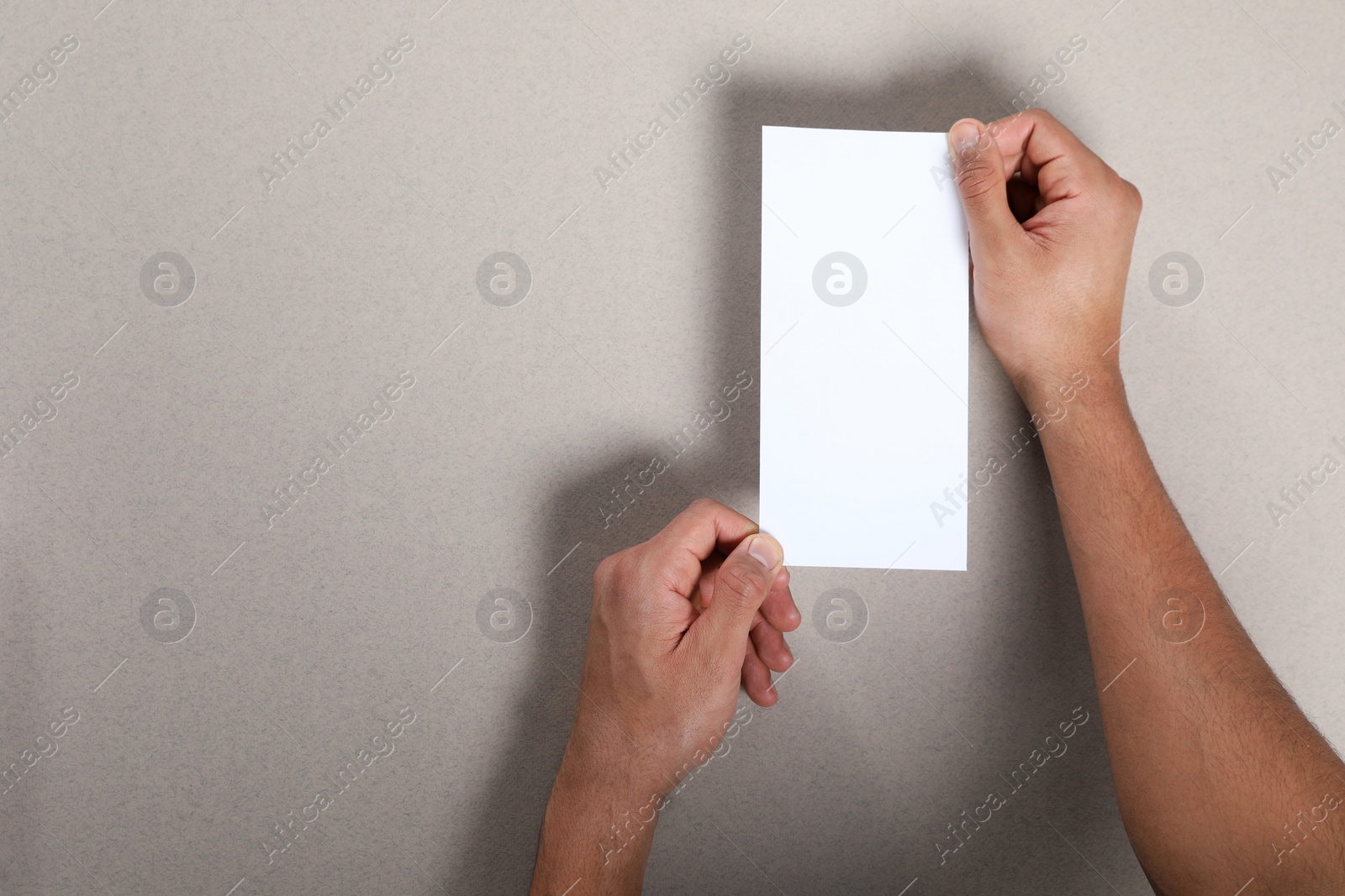 Photo of Man holding flyer on grey background, closeup. Mockup for design