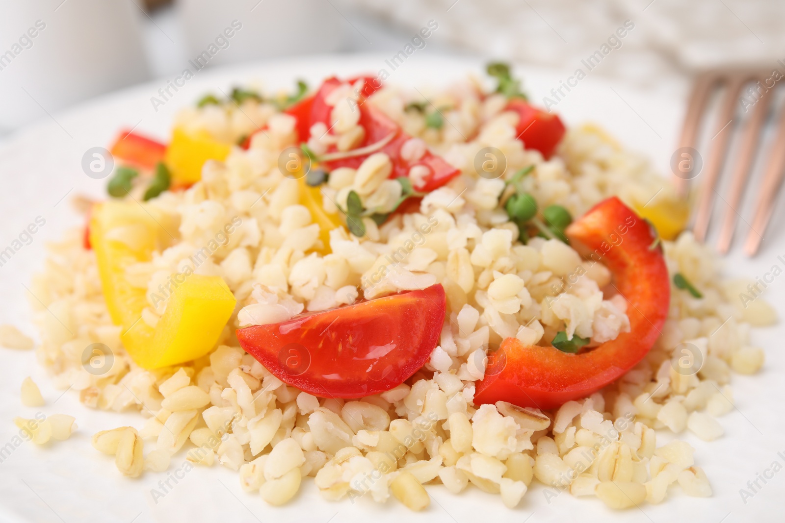 Photo of Cooked bulgur with vegetables on plate, closeup