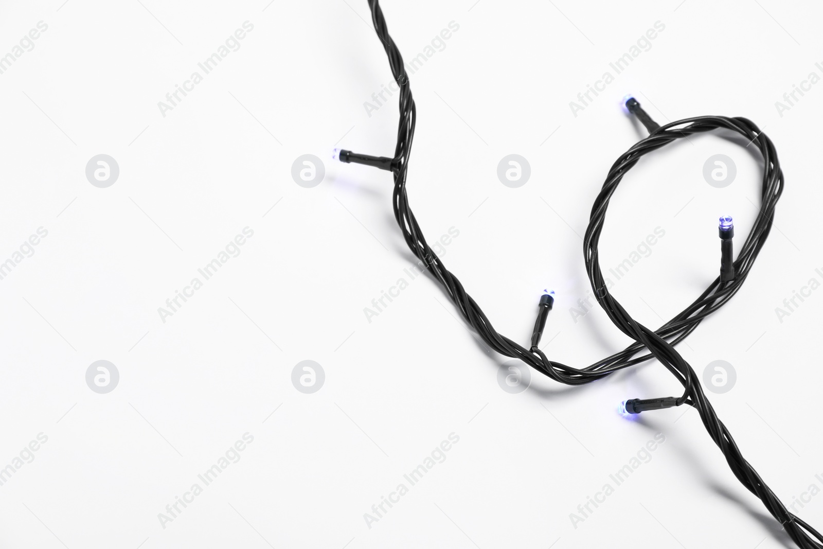 Photo of String of beautiful Christmas lights on white background