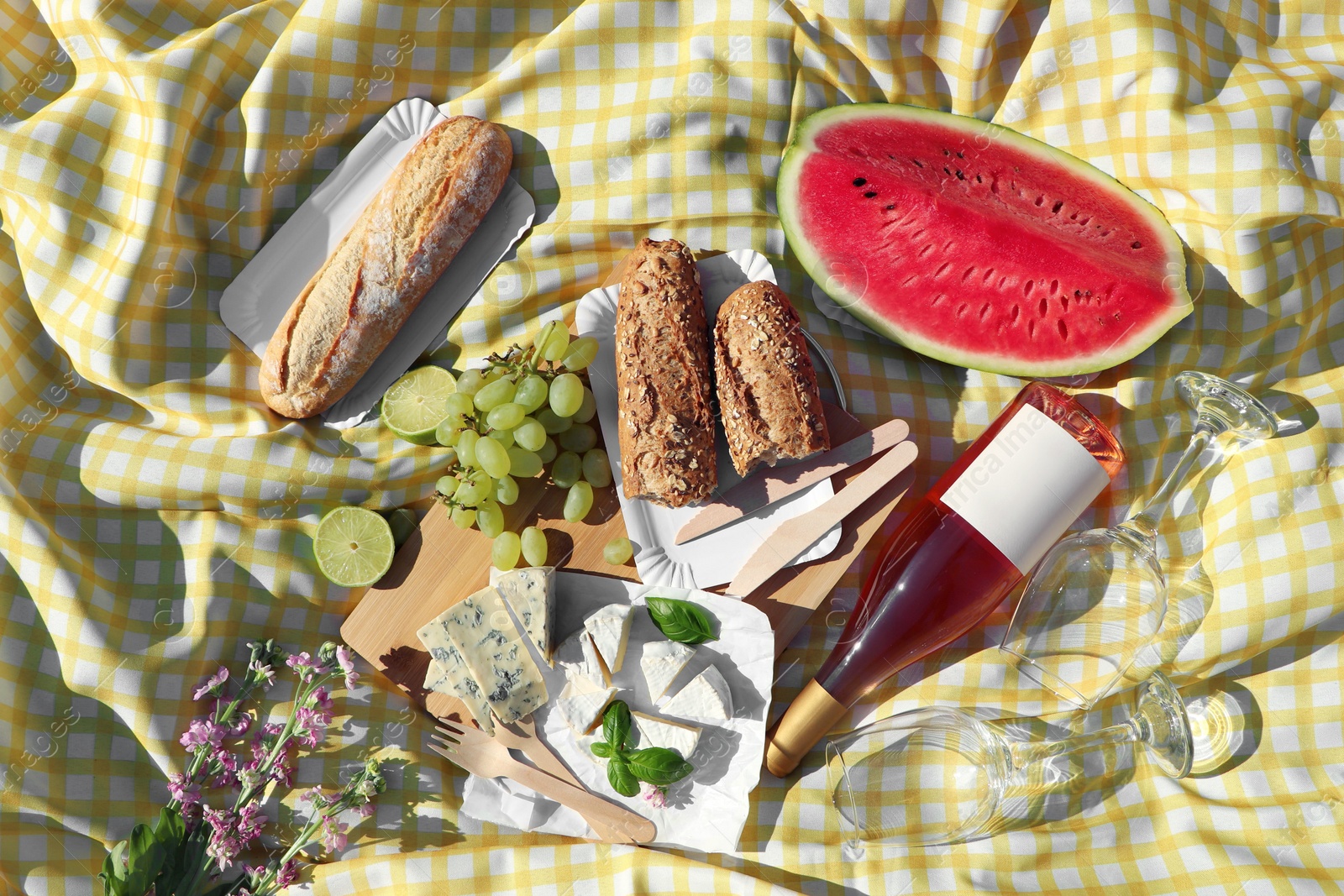 Photo of Delicious food and wine on picnic blanket, flat lay