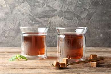 Glass cups with tasty tea on wooden table